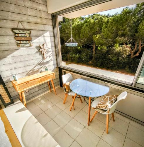 un balcon avec une table, des chaises et une fenêtre dans l'établissement Le Bali, à La Seyne-sur-Mer