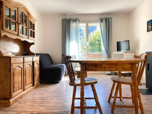 un salon avec une table en bois et un canapé dans l'établissement Résidence Pifourcha La Roche Entre Sisteron & Serre-Ponçon, à Le Caire