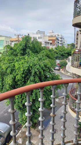 a balcony with a fence and a tree at Apartamento na praia do forte in Cabo Frio