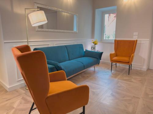 a living room with a blue couch and two chairs at B&B Olea Tarsia in Tarsia