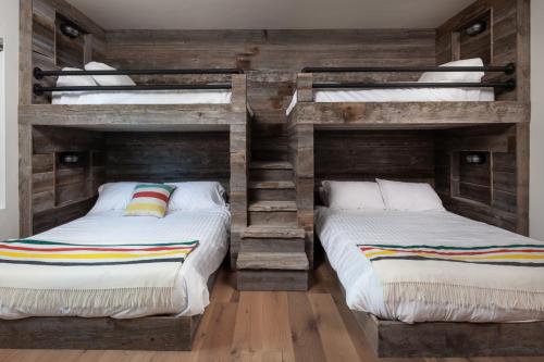 two bunk beds in a room with wooden walls at Lodge at Whitefish Lake in Whitefish
