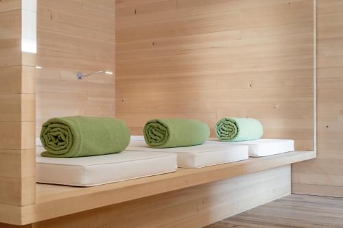 two green pillows sitting on a bench in a sauna at Alpenhotel Krone in Pfronten