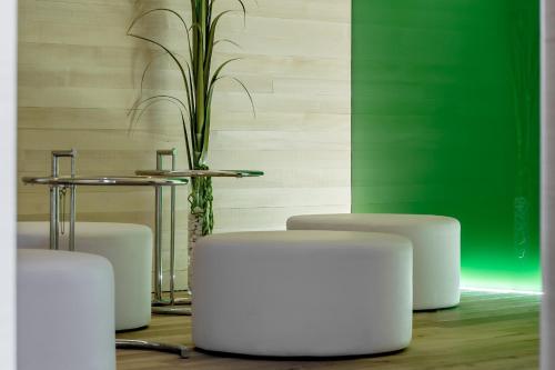 a room with white stools and a table with a plant at Alpenhotel Krone in Pfronten