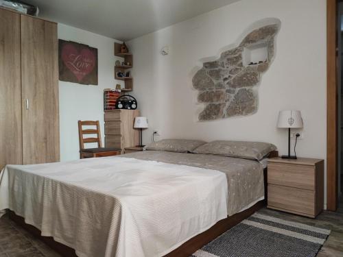 a bedroom with a large bed and a stone wall at Skulka Apartment - Cres Island in Orlec