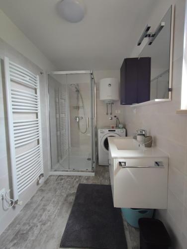 a white bathroom with a shower and a sink at Skulka Apartment - Cres Island in Orlec
