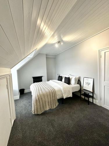 a bedroom with a bed with a white ceiling at Luxury 5 bed Salford home free parking in Manchester