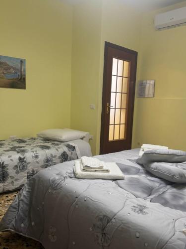 a bedroom with two beds with towels on them at La Petite Maison de Grand-Mére Assunta in Nola