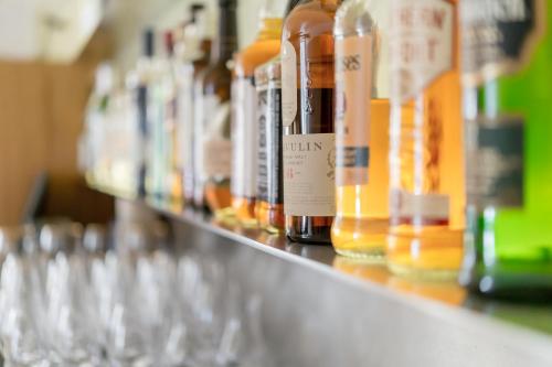 a row of bottles and glasses on a shelf at Alpenhotel Krone in Pfronten