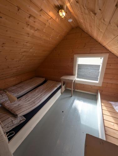 a bedroom in a log cabin with a bed and a window at Charming guest house with amazing view in Kvam