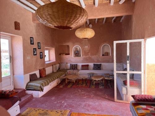 a living room with a couch and a table at Tigmi Hamid Découverte des traditions et de la culture berbère in Aït Ben Haddou