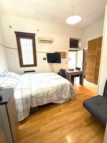 a bedroom with a bed and a desk and a television at Grazia's Heaven in Trezzo sullʼAdda