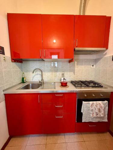 a kitchen with red cabinets and a sink at Grazia's Heaven in Trezzo sullʼAdda