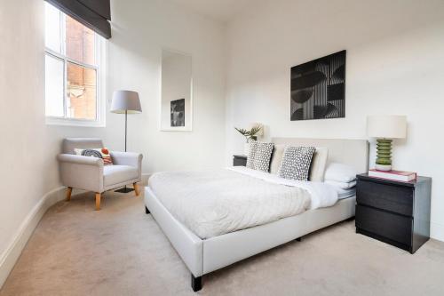a white bedroom with a bed and a chair at Modern City Centre Apartment - Sleeps 4 - ideal for families, couples & professionals in Leicester