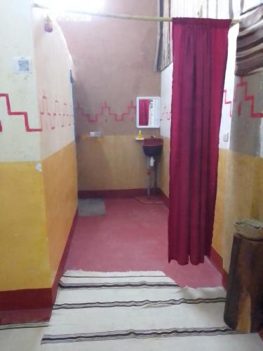 a room with a red curtain and a red carpet at Ait Sedrate Tourism Cooperative Hotel in Boumalne