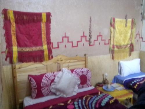 a room with two beds and a city mural on the wall at Ait Sedrate Tourism Cooperative Hotel in Boumalne