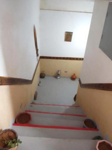 a stairway with red stairs in a room at Ait Sedrate Tourism Cooperative Hotel in Boumalne
