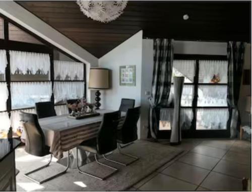 a dining room with a table and chairs and windows at Ferienwohnung Schindele am Bodensee in Langenargen
