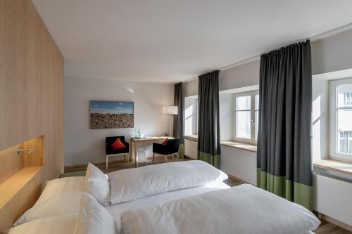 a hotel room with a bed and a desk at Alpenhotel Krone in Pfronten
