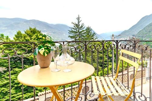 a table with two glasses and a plant on a balcony at Blue Como Luxury APT #2 in Como