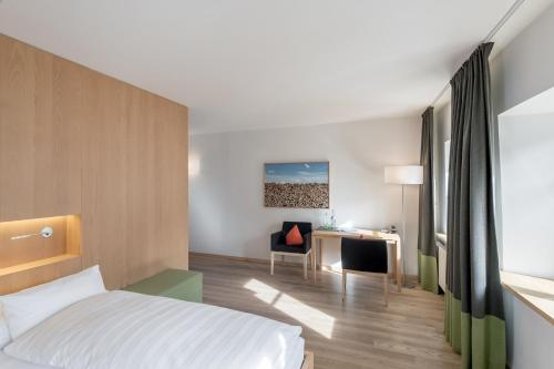 a hotel room with a bed and a desk at Alpenhotel Krone in Pfronten