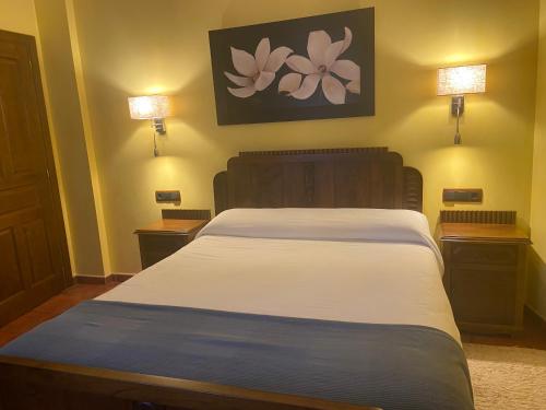 a bedroom with a bed with two night stands and two lights at Hotel Apartamento Marouco in A Guarda