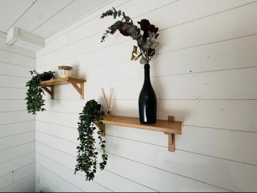 a black vase sitting on a shelf on a wall at Le Refuge de Guilmä in Ludon-Médoc
