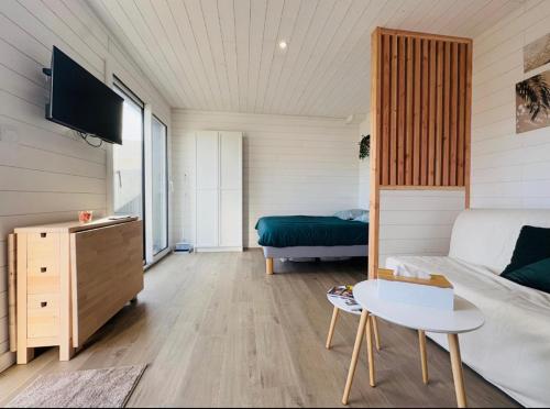 a living room with a bed and a couch at Le Refuge de Guilmä in Ludon-Médoc