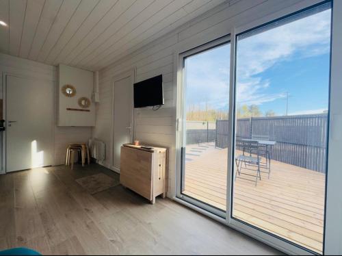 a living room with a balcony with a sliding glass door at Le Refuge de Guilmä in Ludon-Médoc