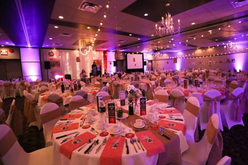 a large banquet hall with white tables and white chairs at Hôtels Gouverneur Trois-Rivières in Trois-Rivières