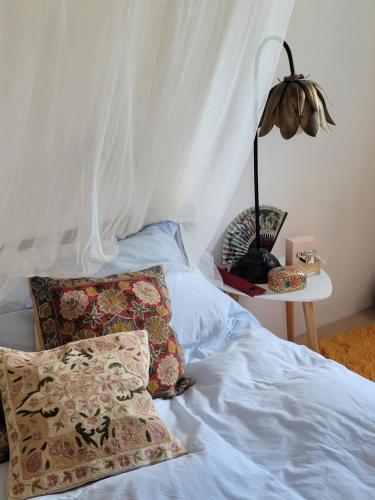 a bed with two pillows and a table with a lamp at Villa Bakola in Sívros