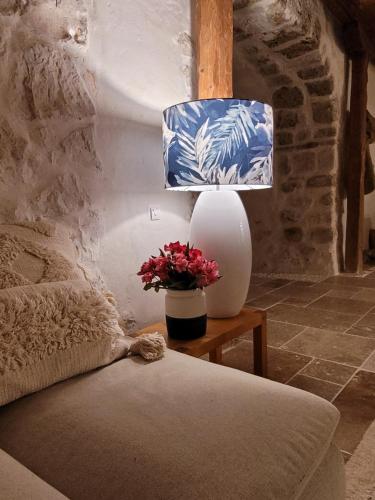 a table with a lamp and a vase with flowers at Villa Bakola in Sívros