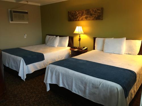 a hotel room with two beds and a lamp at Kentucky Lake Inn in Gilbertsville