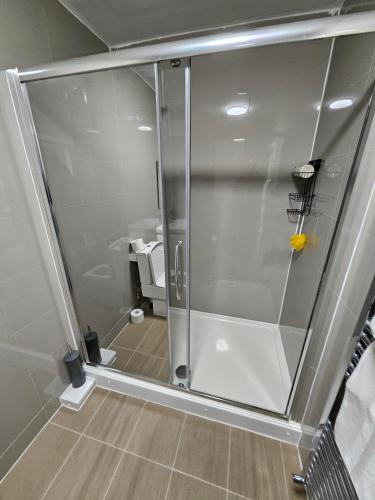 a shower with a glass door in a bathroom at Kingdom apartments in Wolverhampton