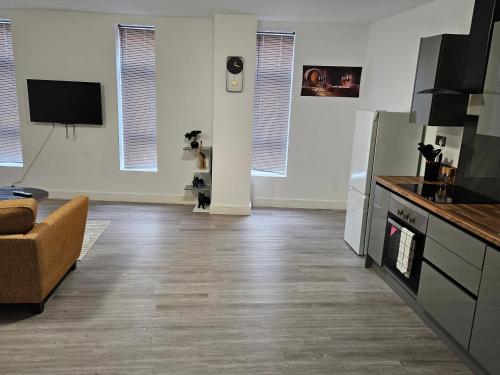 a room with a kitchen with a couch and a tv at Kingdom apartments in Wolverhampton