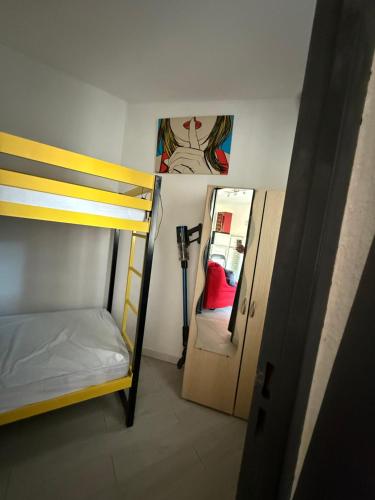 Cette petite chambre comprend des lits superposés et une porte. dans l'établissement Charmant studio cabine sur le port de Carnon-Plage, à Mauguio