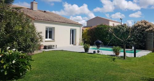 un homme marcher son chien près d'une piscine dans l'établissement Maison privée avec piscine, à Talmont-Saint-Hilaire