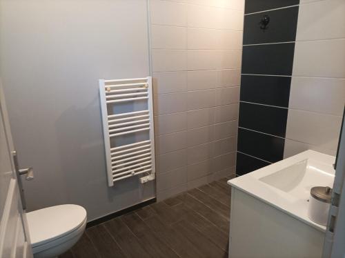 une salle de bain avec des toilettes blanches et un lavabo dans l'établissement Maison privée avec piscine, à Talmont-Saint-Hilaire