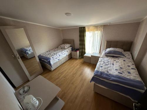 a small room with two beds and a mirror at Family hotel in Gori