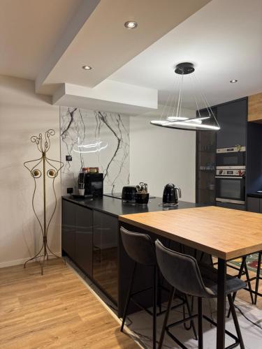 une cuisine avec une table en bois et des armoires noires dans l'établissement Villa avec piscine, à Alata