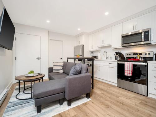 a living room with a couch and a kitchen at Cozy Studio Apt - Corktown Hamilton - Near DT in Hamilton