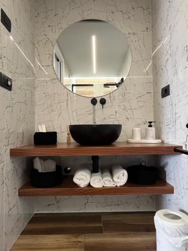 un bagno con lavandino, specchio e asciugamani di Bellavista - Superior rooms ad Agerola
