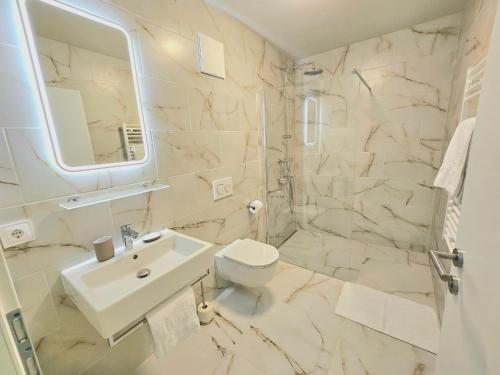 a white bathroom with a sink and a toilet at Der Franzlhof in Laxenburg