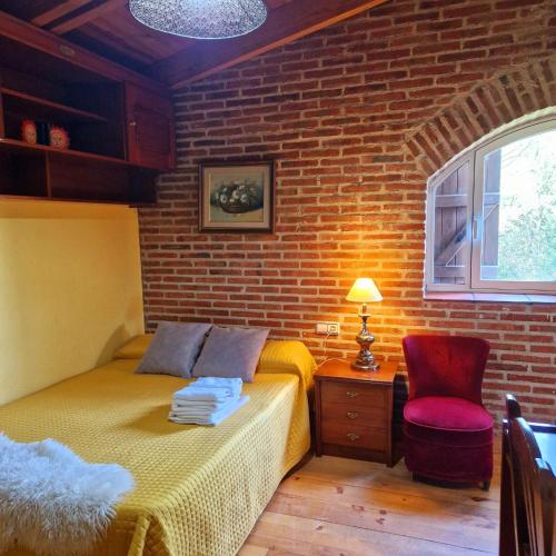 a bedroom with a bed and a brick wall at Hostal del Currante Babilafuente in Babilafuente
