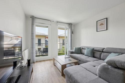 un salon avec un canapé et une table dans l'établissement Paris Disney an unforgettable stay comfortable, à Montévrain