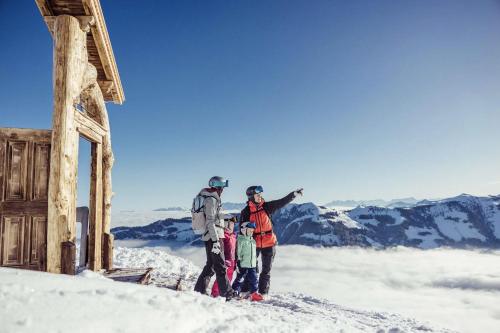 a family standing on top of a snow covered mountain at PENTHOUSE N`3 - Stylish Apartment with Rooftop Whirlpool Access in Tyrol, presented by AlpenLuxus in Kramsach