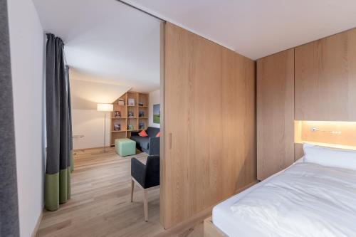 a bedroom with a bed and a chair in a room at Alpenhotel Krone in Pfronten