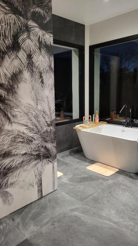 une salle de bain avec baignoire et une grande fenêtre dans l'établissement Villa Luna, à La Teste-de-Buch