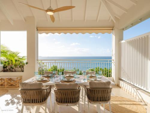 a dining room with a view of the ocean at Chez Paulette à distance à pied de la plage et piscine chauffée in Friar's Bay