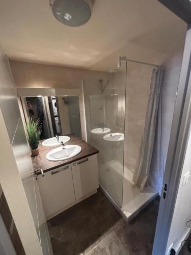 une salle de bain avec deux lavabos et une douche dans l'établissement Appartement cosy au cœur de port vendres, à Port-Vendres
