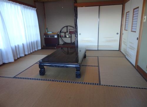 a room with a table in the middle of a room at 旅ポストのの花 in Kawana